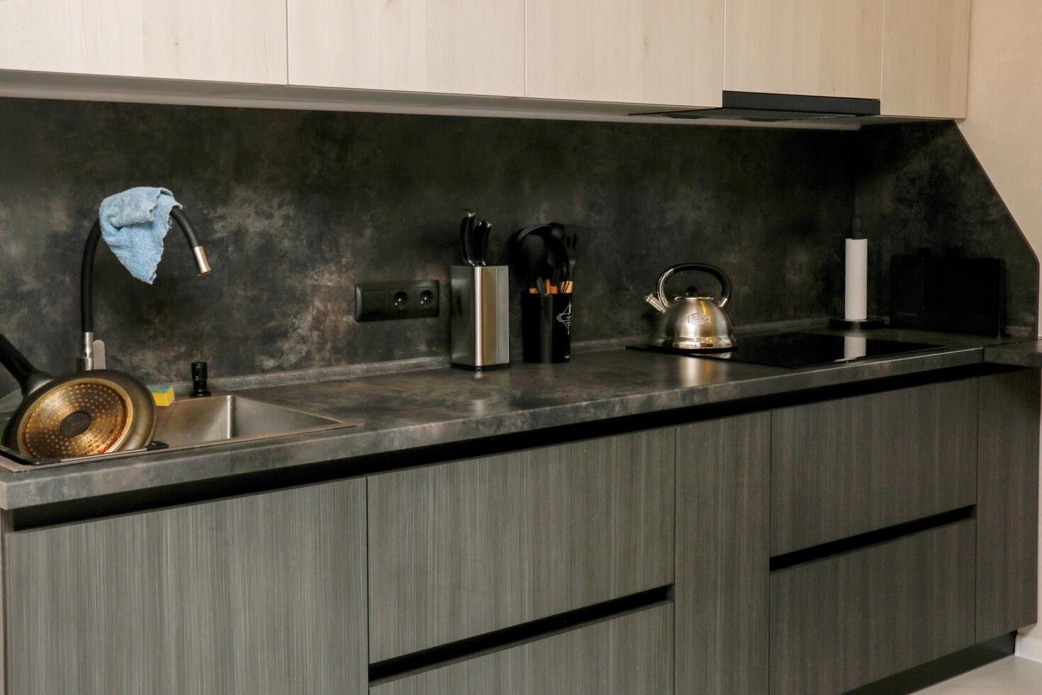 kitchen worktop with built-in induction hob, sink with kitchen utensils photo