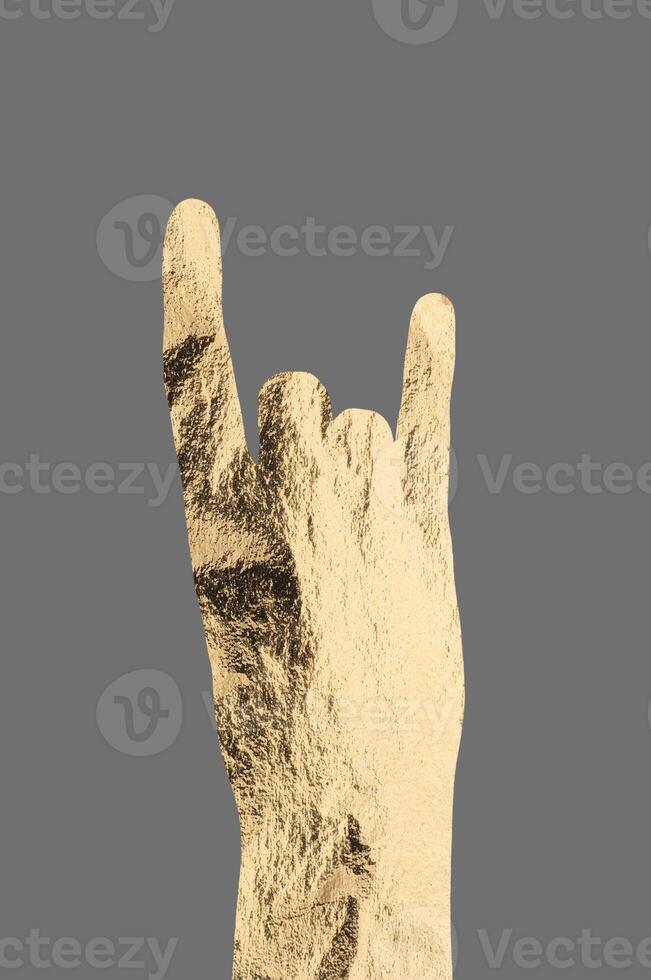 Rock gesture with hand showing golden metallic horns, symbolizing energy, rebellion, and enthusiasm. photo