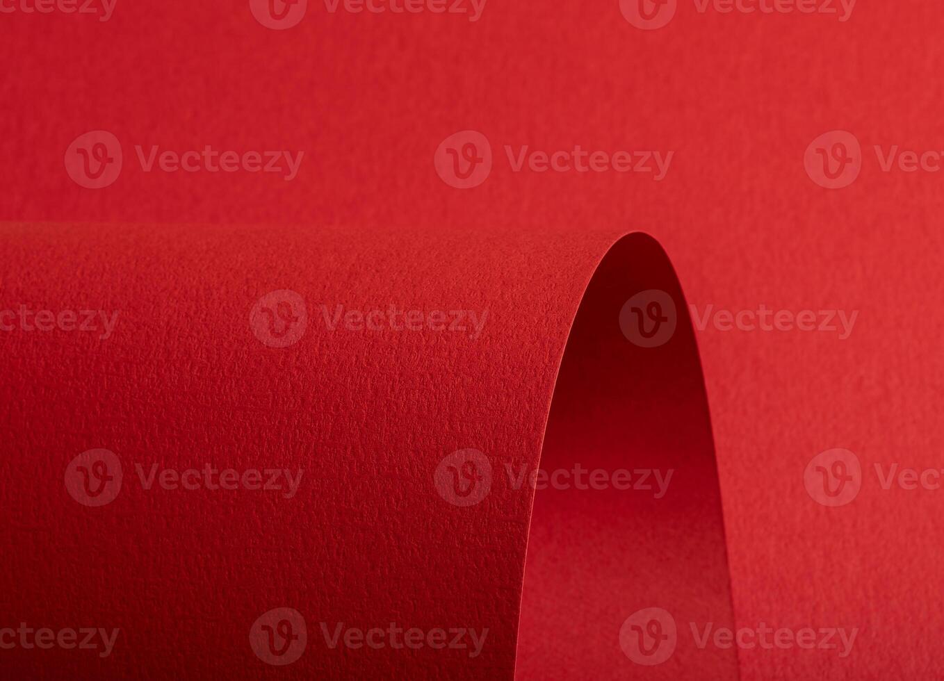 Red paper texture with vibrant fire red and scarlet tones, textured surface with rolled and curved photo