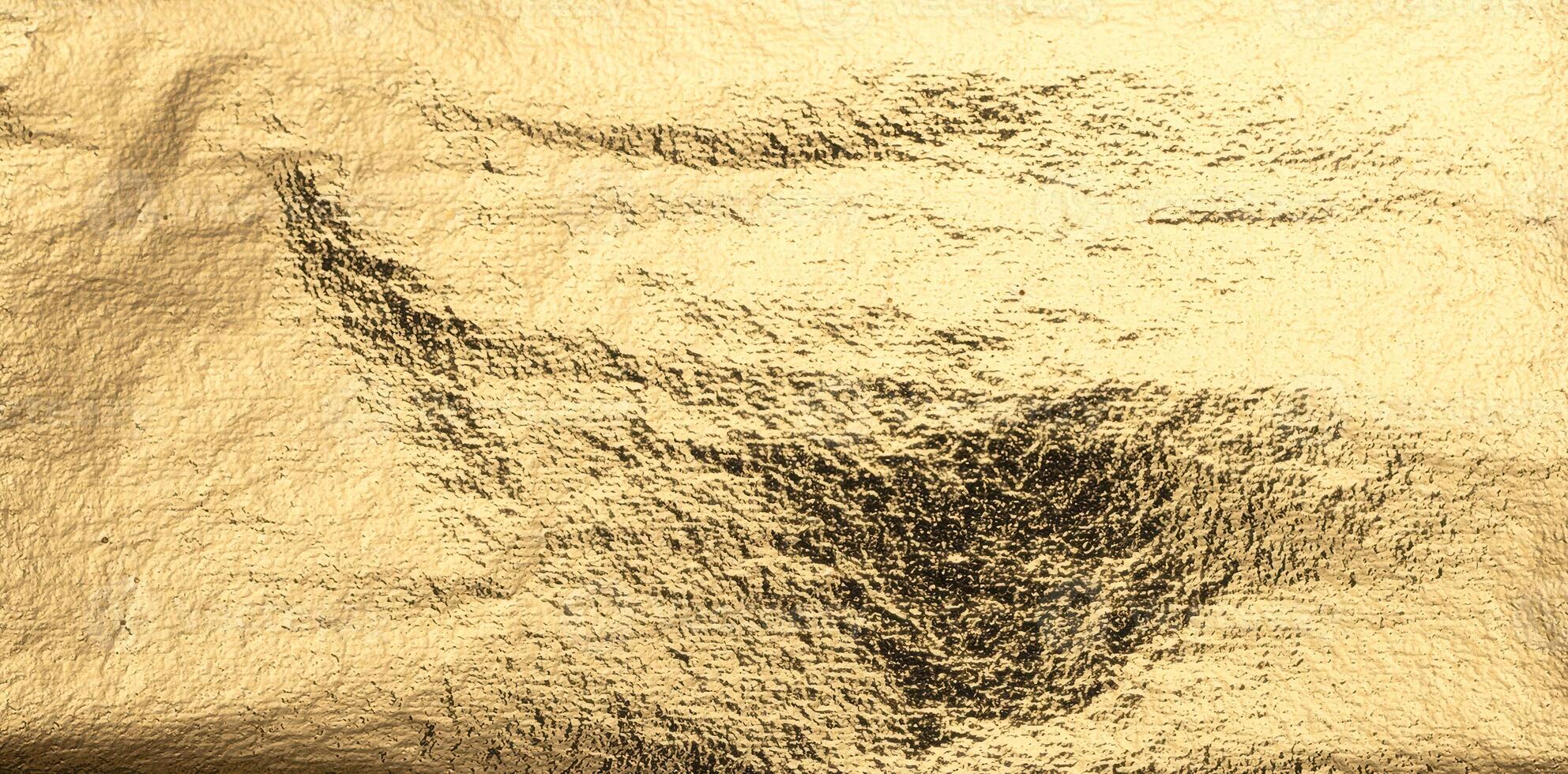 Golden foil texture with a shiny, crumpled surface and dark, distressed patches. Abstract gradient photo