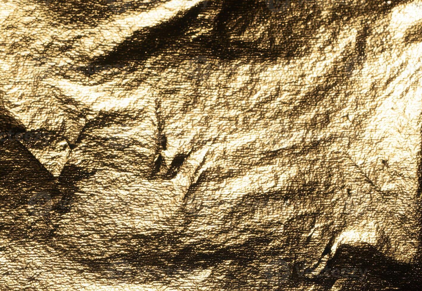 Golden foil with crumpled, metallic texture creates a dramatic, reflective surface. Shiny, embossed photo