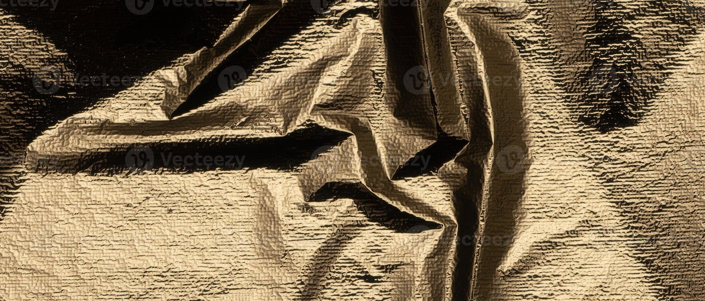 Golden foil paper with a crumpled, reflective texture. Chic and stylish drapery, showcasing a shiny, photo