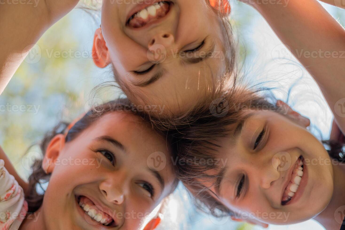 Close up face of happy children embracing each other and smiling, group of joyful kids playing together outside. photo