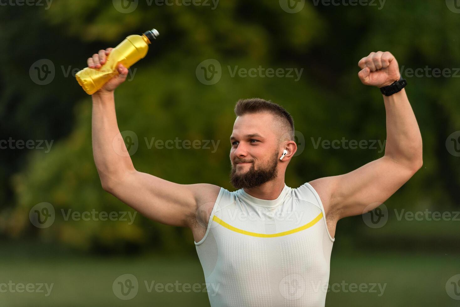 Strong fit young happy man raising fist up after successful finished run. Concept of sports triumph, victory. photo
