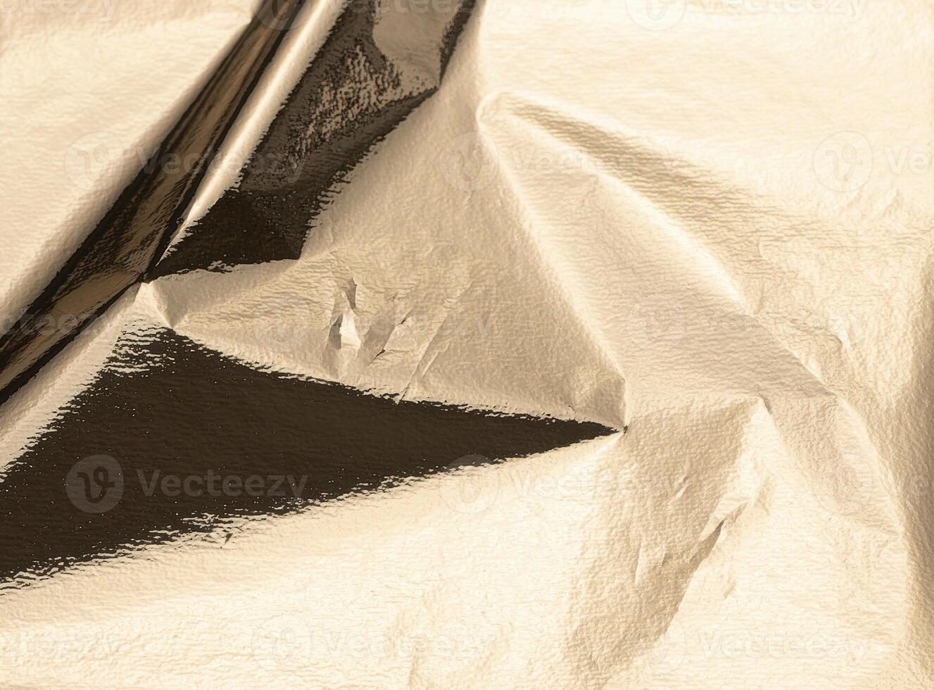 Gold foil texture with a crinkled, shiny surface. Elegant vintage metallic material with a sleek, photo