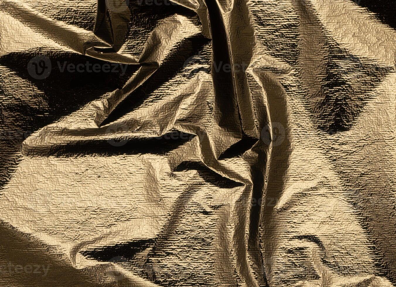 Gold foil fabric background with a sleek, crumpled texture. Shiny, soft surface with elegant folds, photo