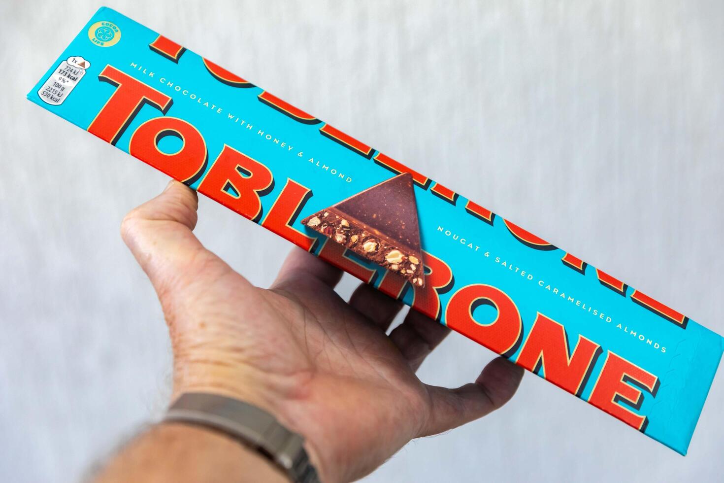 Brazil, May 10, 2025. Toblerone chocolate with salt and almonds and chestnuts on hand photo