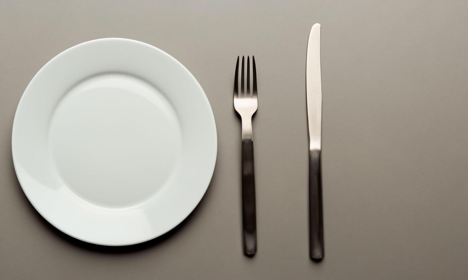 Plate and cutlery isolated on plain background in top view real photo
