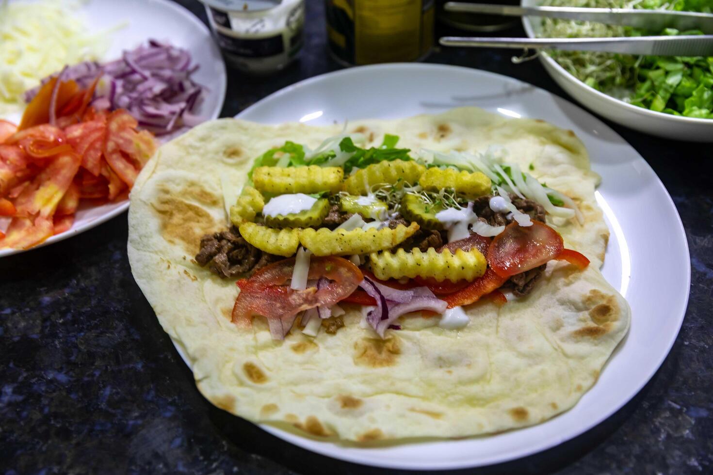 The most traditional and classic shawarma prepared in Syrian bread or pita bread grilled on a stone open photo