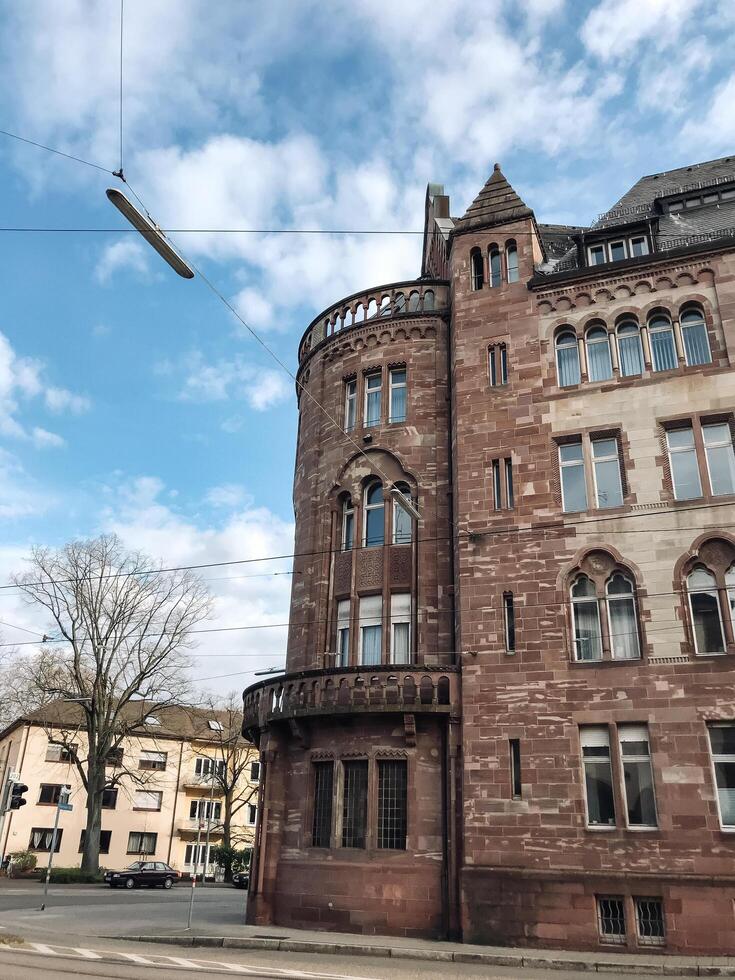 Karlsruhe, Germany - April 16, 2022 - A large brick building with a balcony and a street scene in the background photo