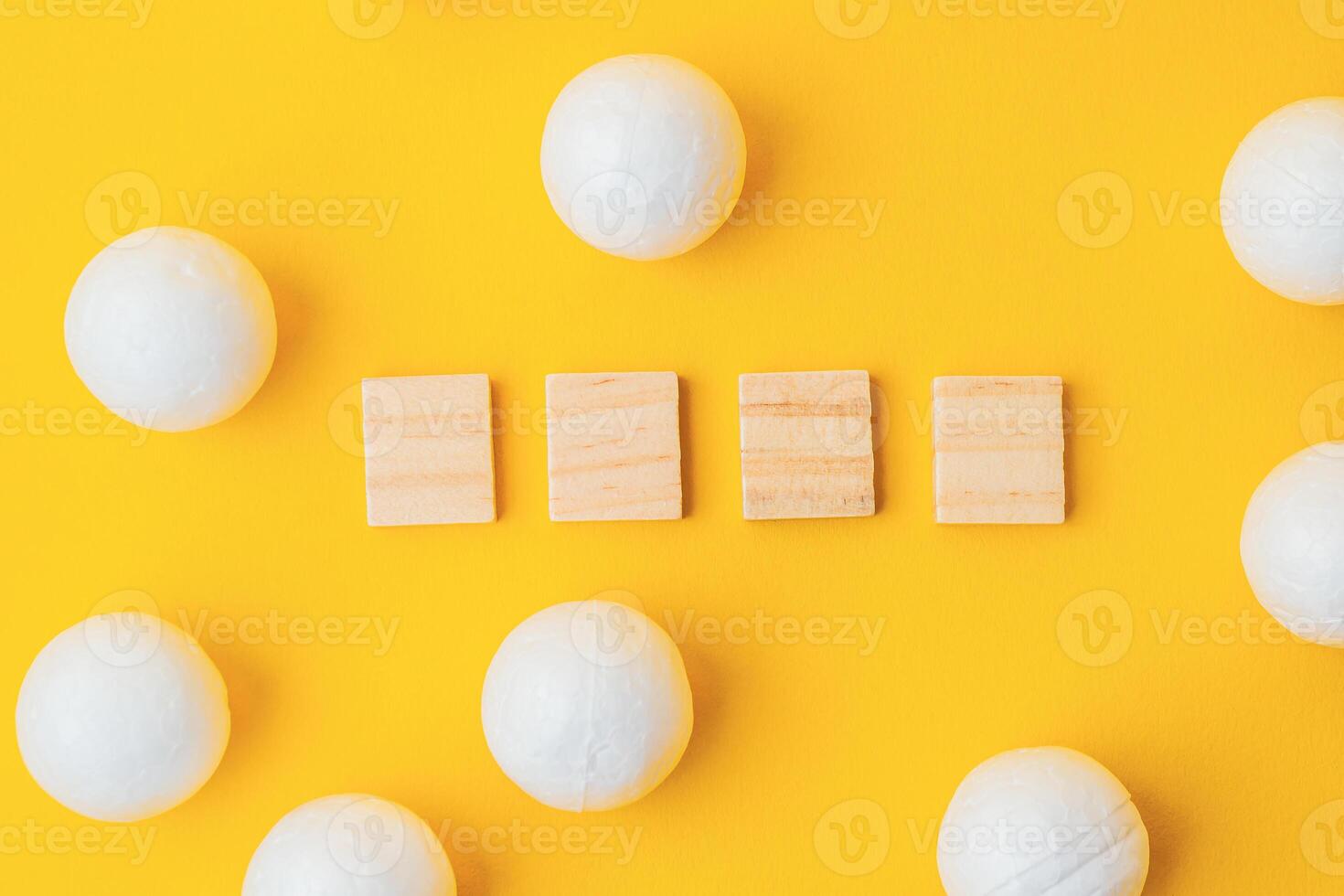 Wooden cubes with spheres on yellow background for minimalistic concept photo
