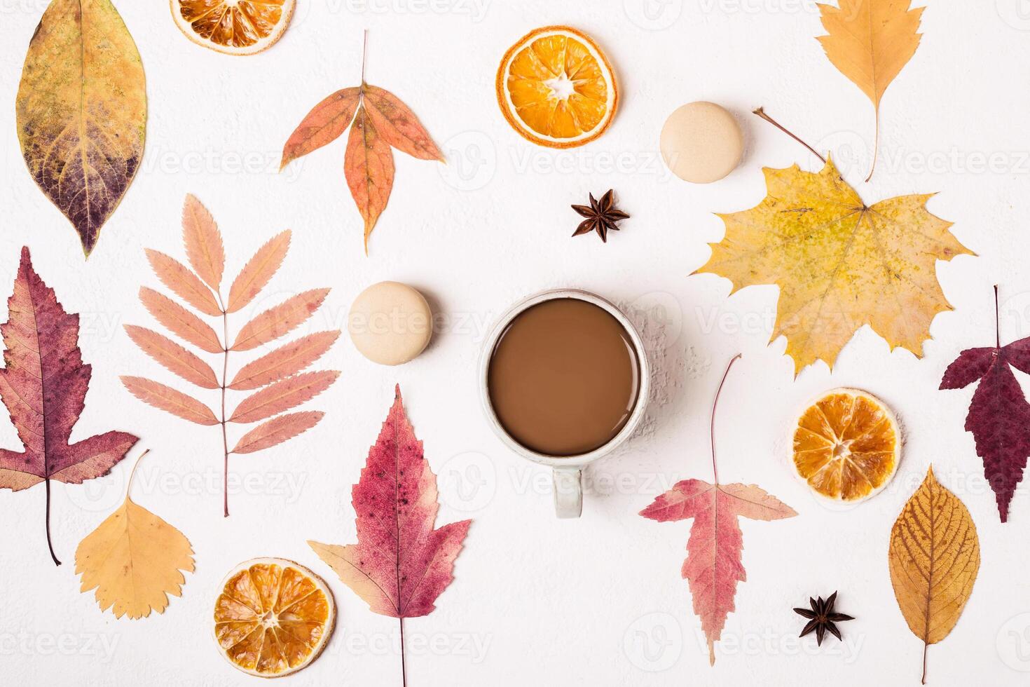 Cup of Coffee on white table with autumn leaves pattern photo