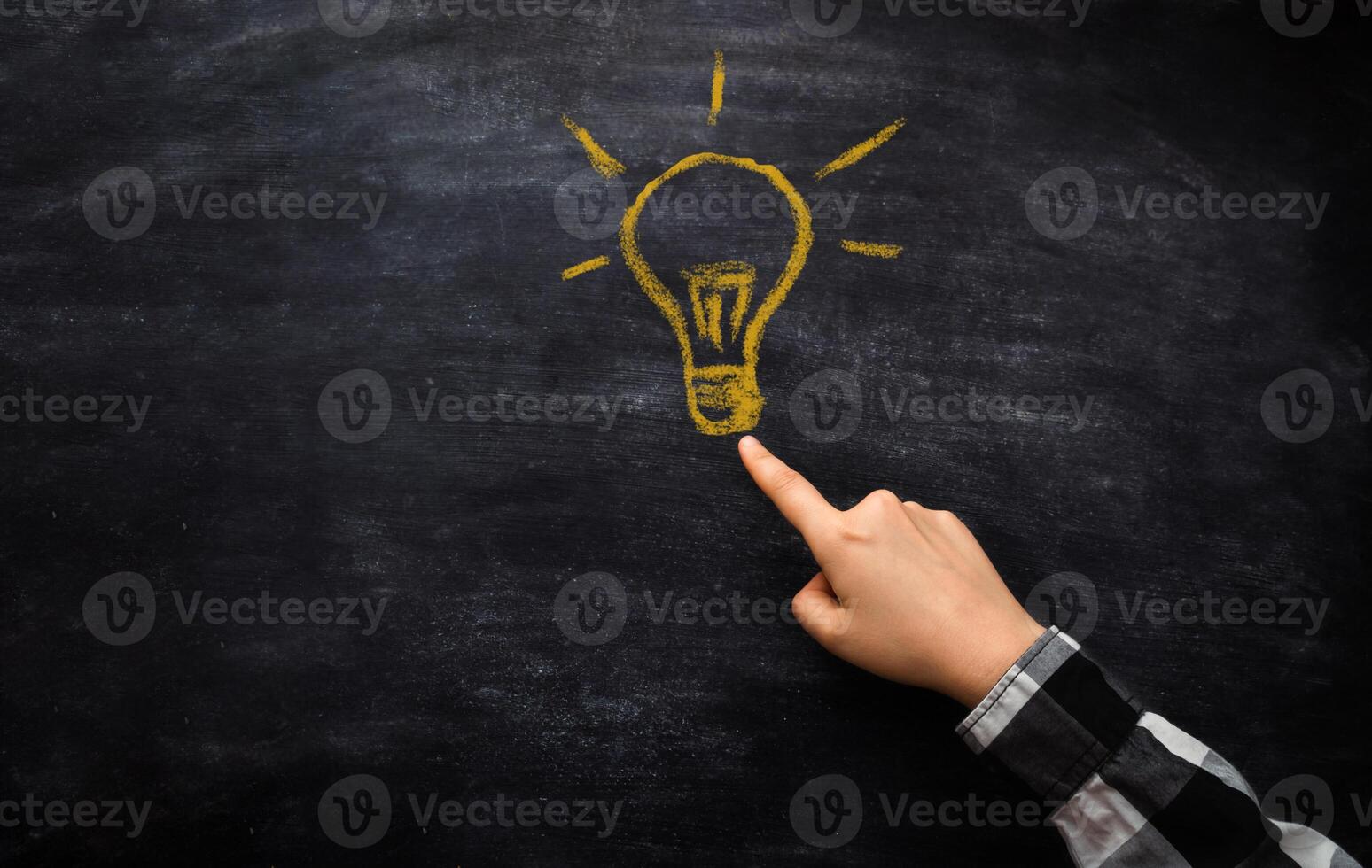 man's hand points to a yellow light bulb Idea photo