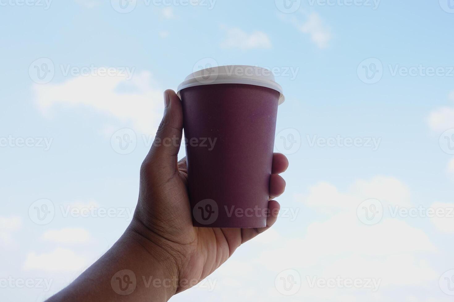 Enjoying a warm drink against a clear blue sky backdrop photo