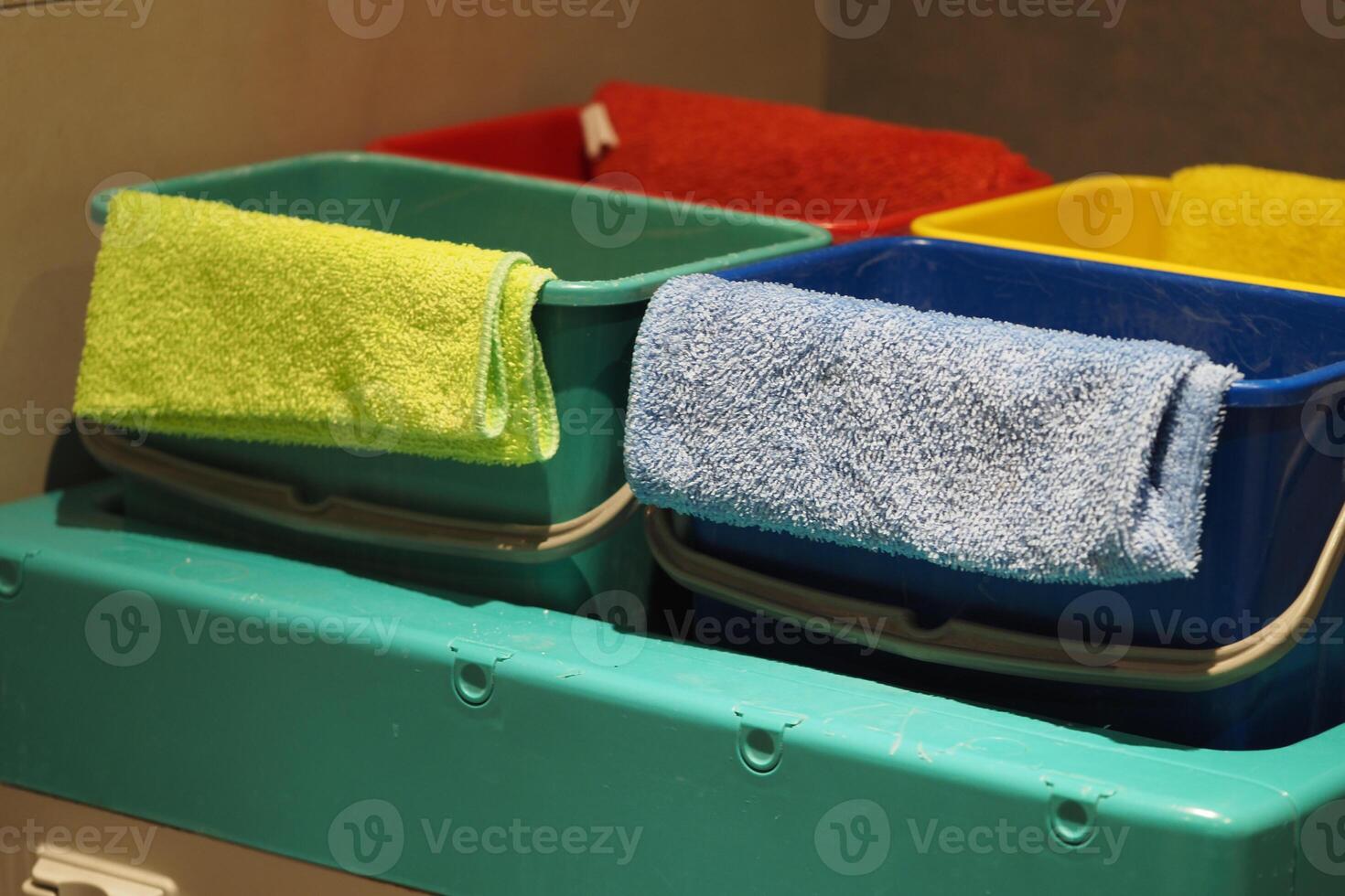 Colorful bins organized with towels in a cleaning area photo