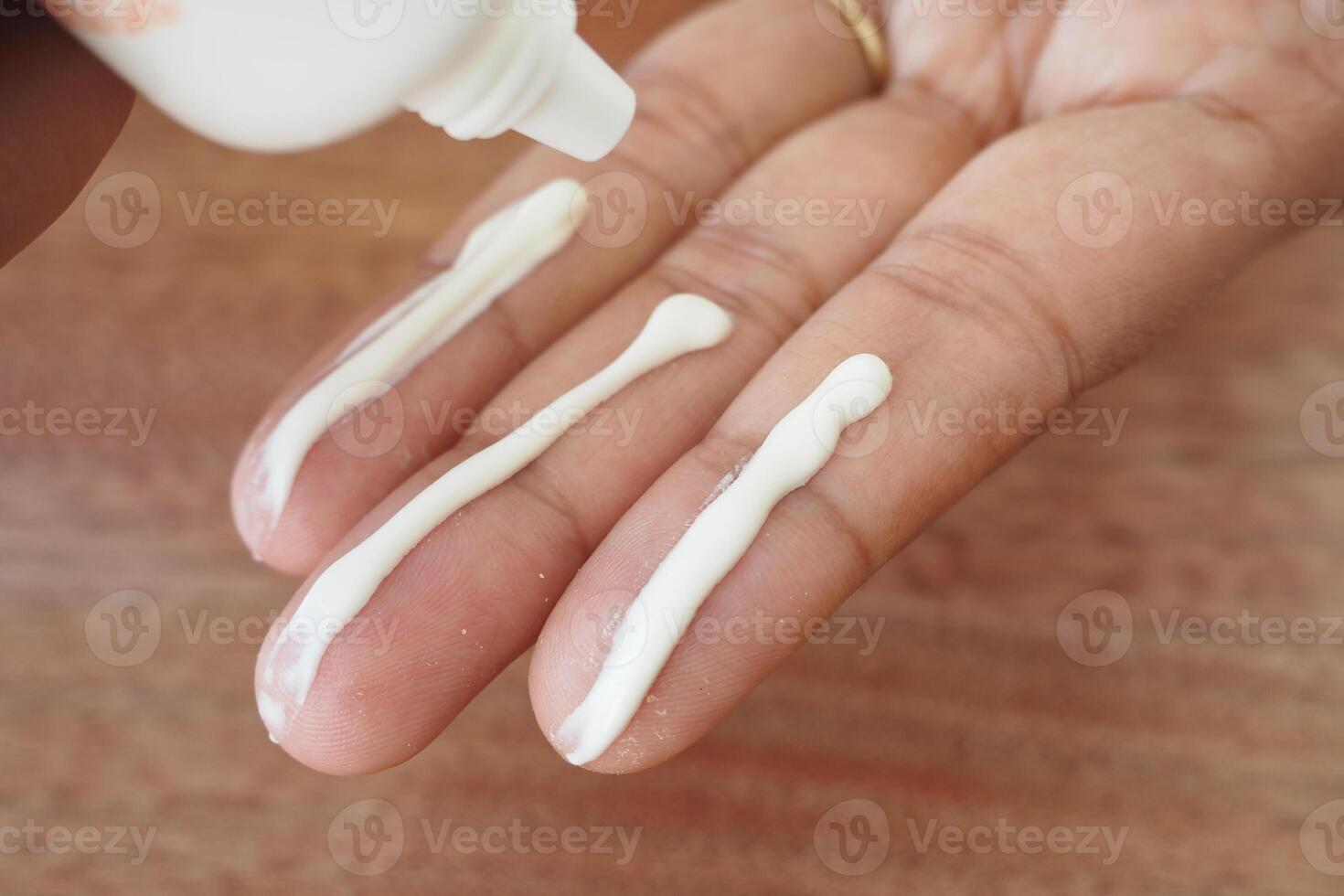 Applying sunscreen cream to fingers for skincare routine photo