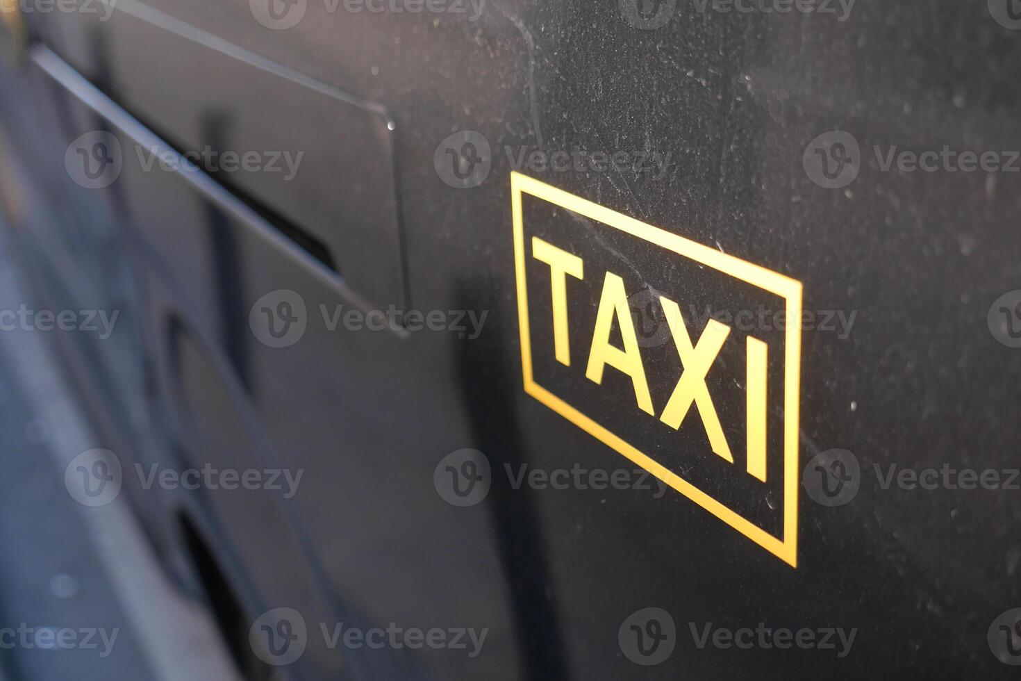 Yellow taxi sign on a black vehicle in the city photo