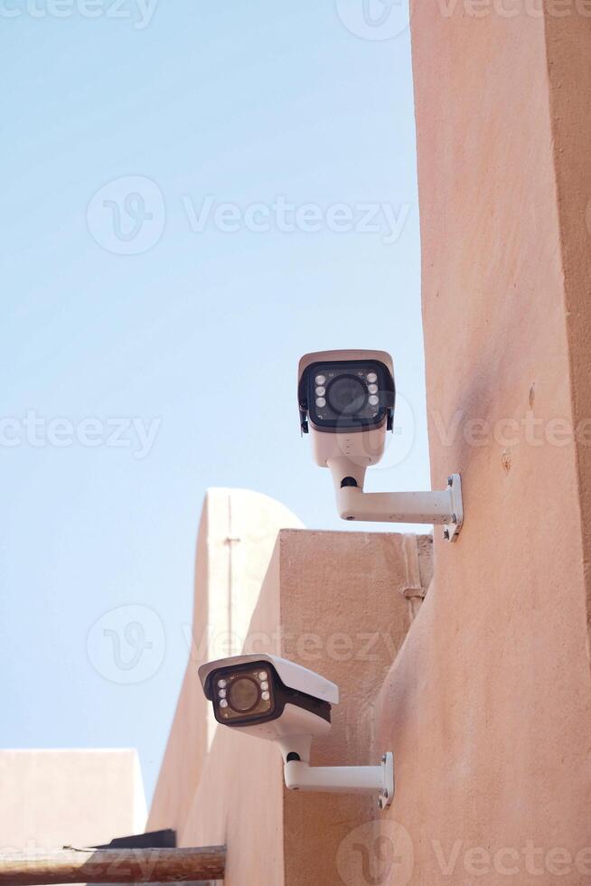 Surveillance cameras mounted on a building in bright daylight photo