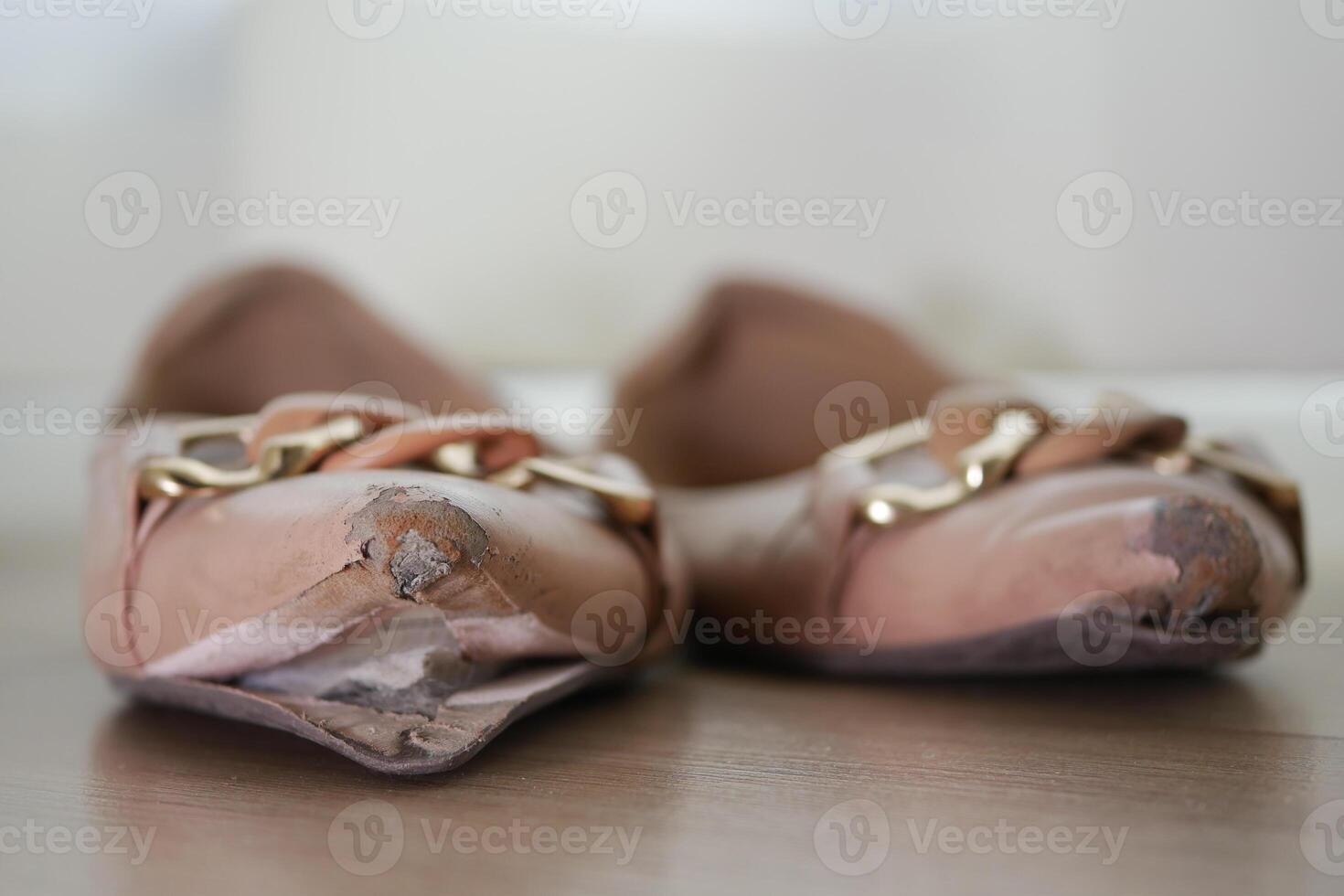 closeup of damage shoes on wooden floor photo