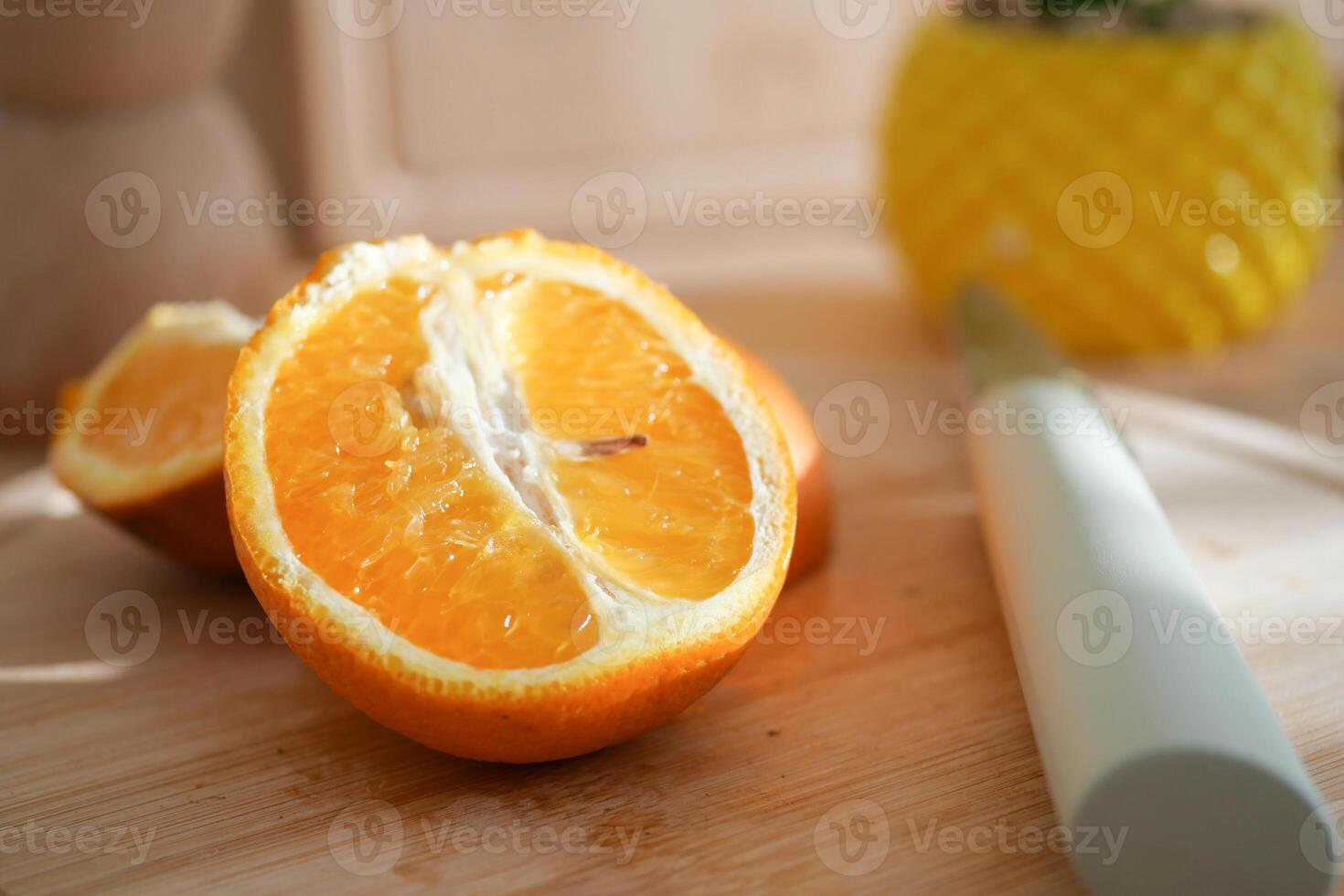 Freshly cut orange placed on a wooden kitchen countertop photo