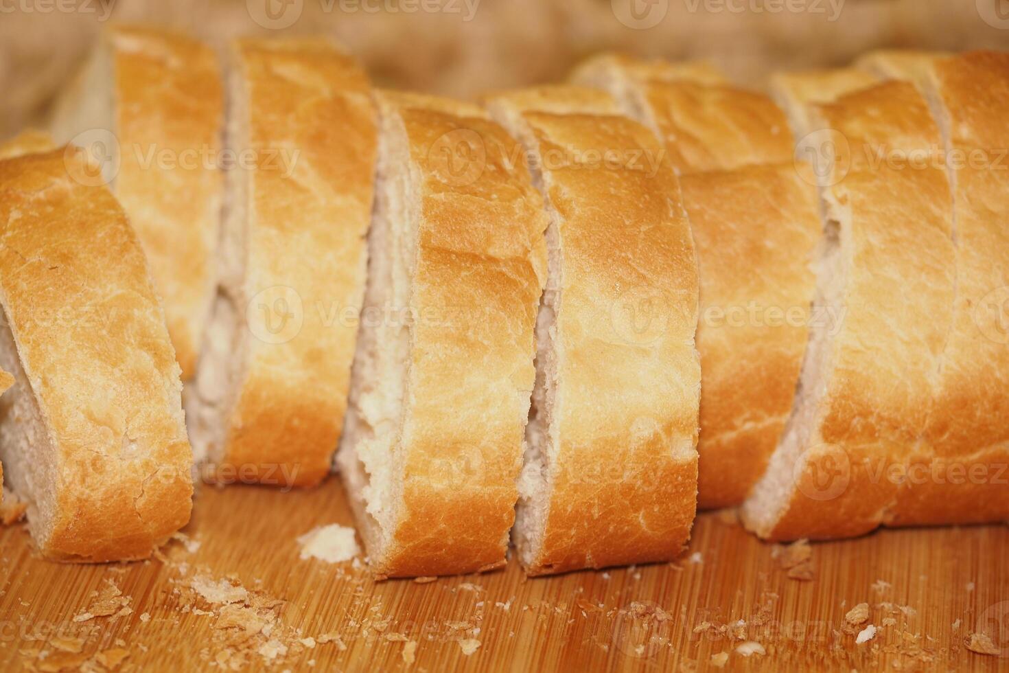 Freshly sliced bread on a wooden cutting board in a kitchen photo