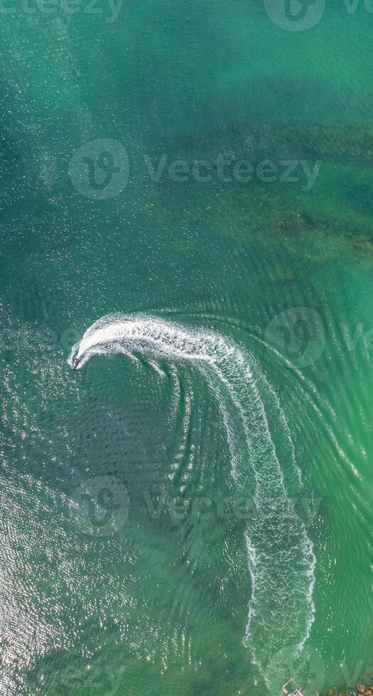 Speed boat in the sea with wake foam on clear water photo