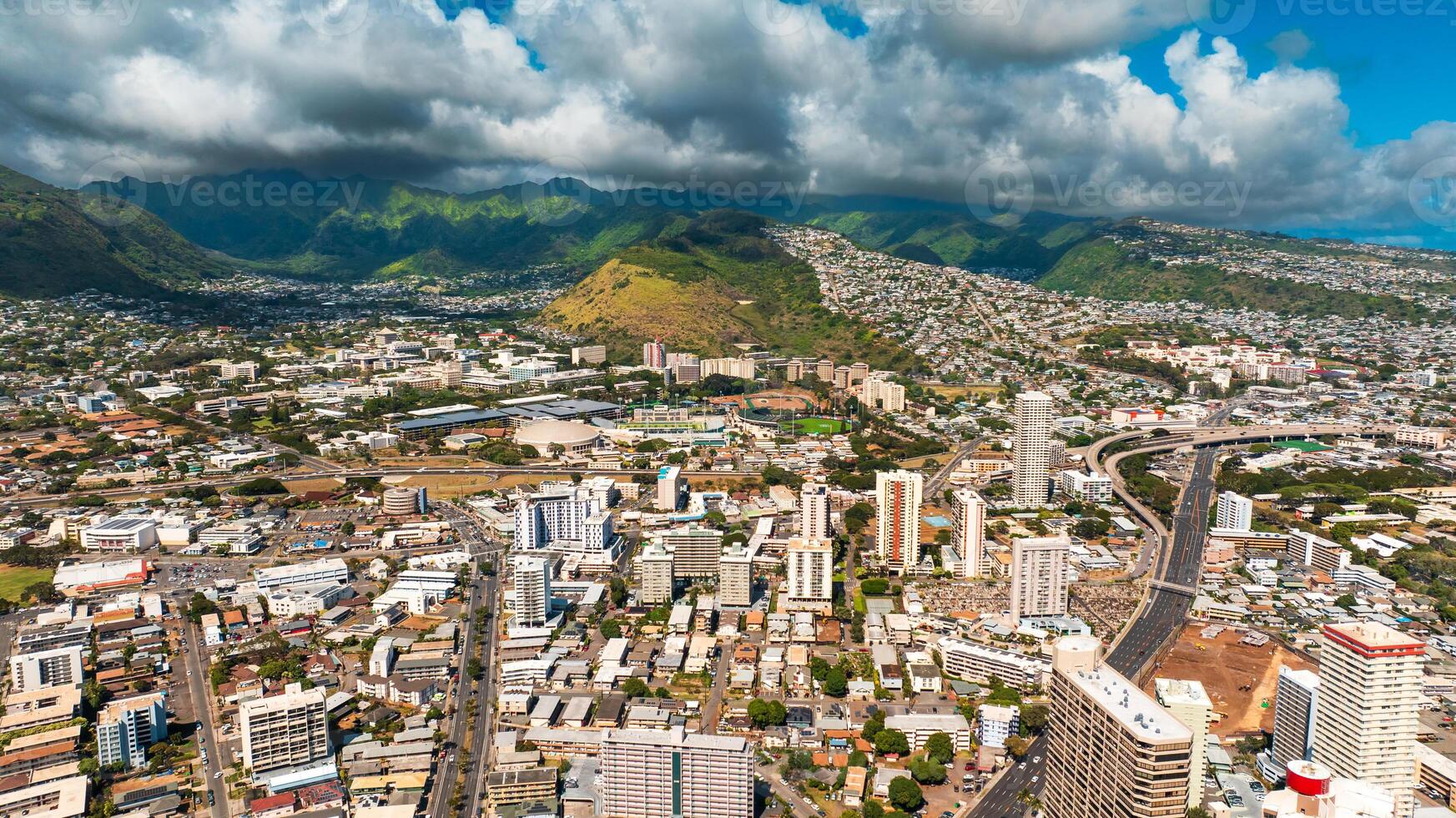 Varied urban landscape of densely built Honolulu, Hawaii, USA. Aerial perspective eon the city under the grey cloudy sky. photo