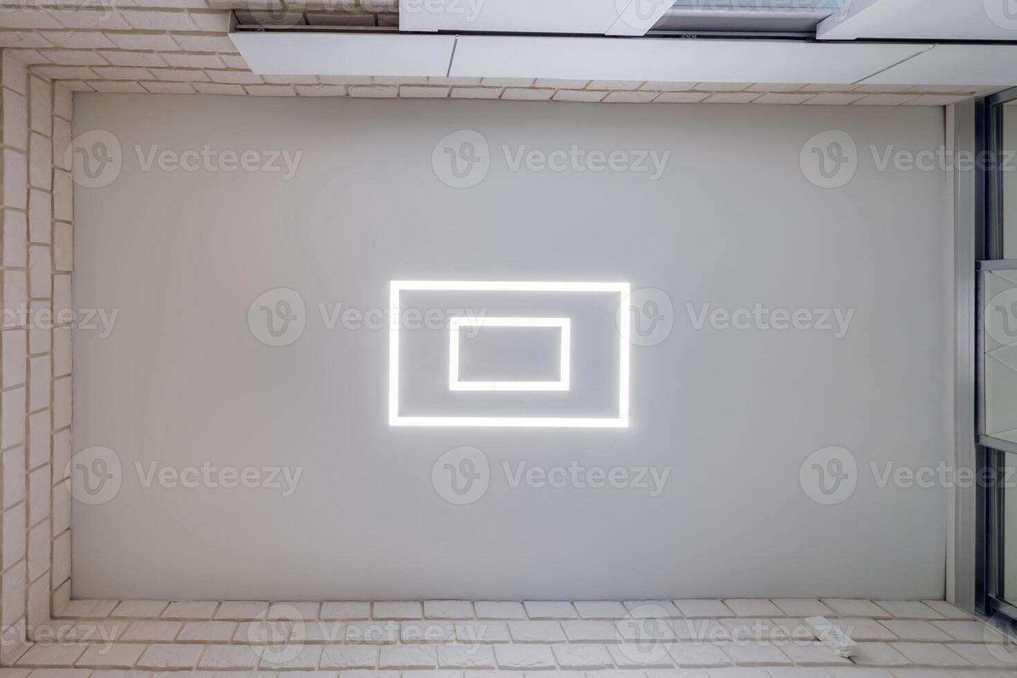 A white square light is on the ceiling of a room photo