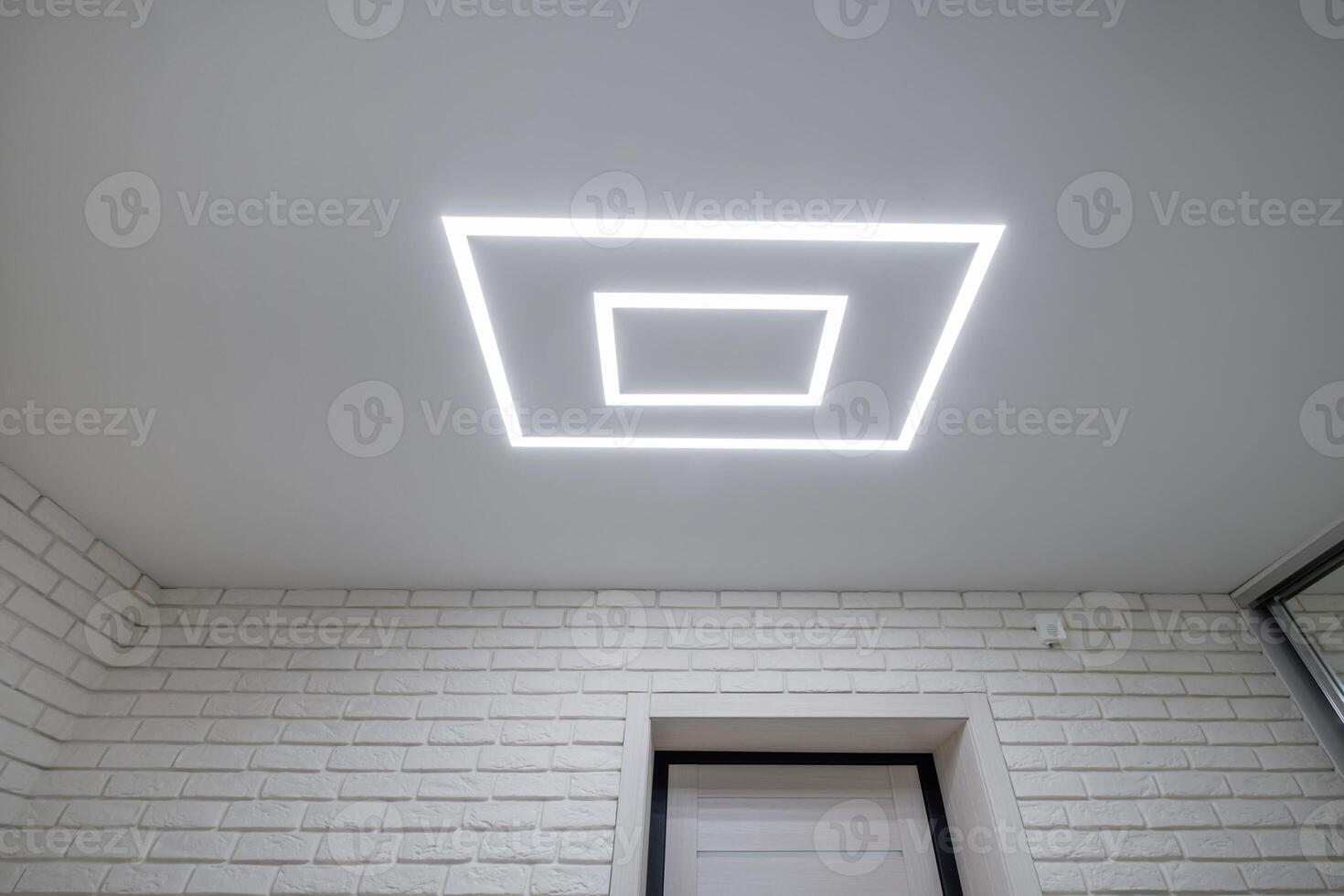A white brick wall with a square light above it photo