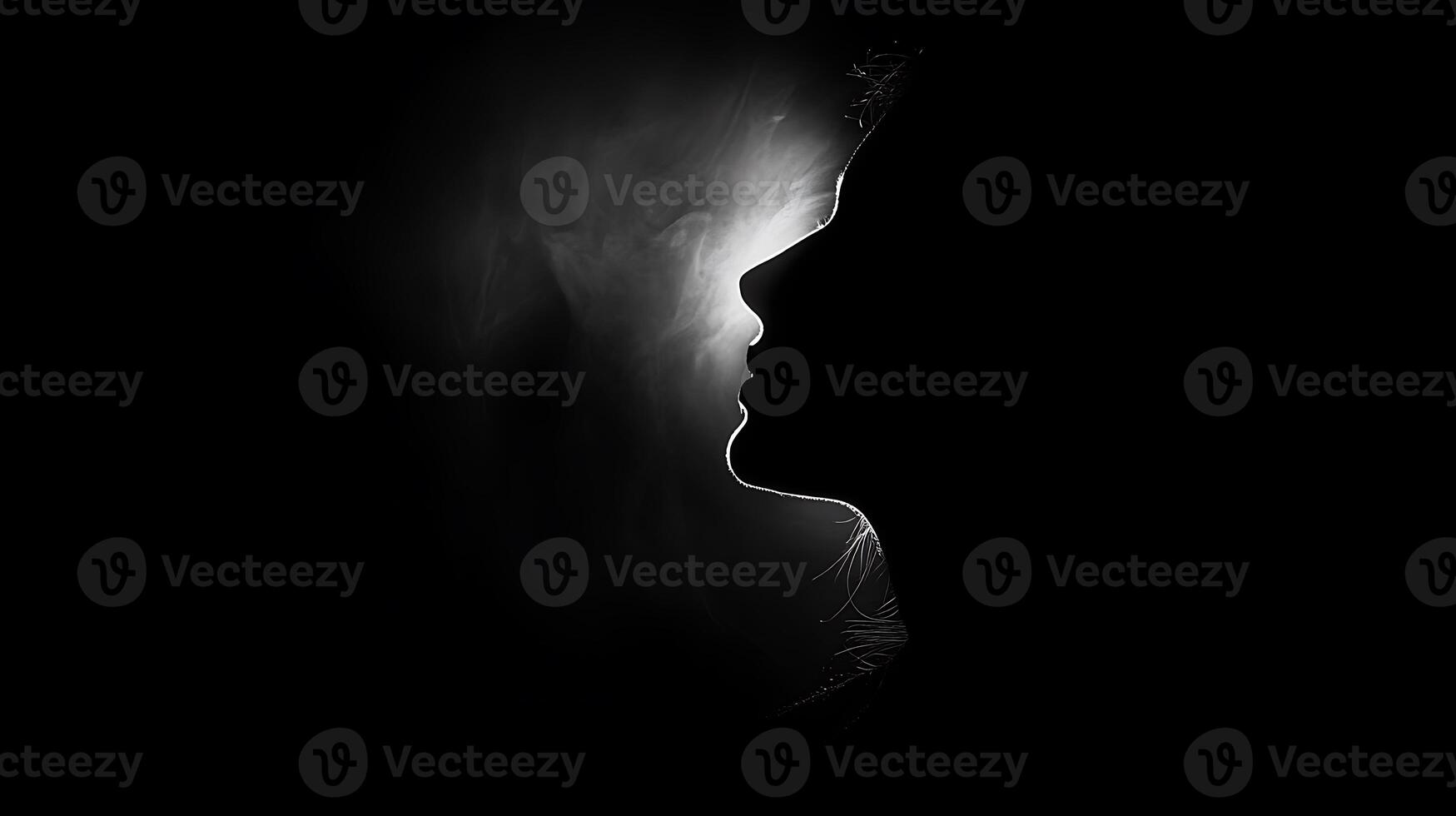 Silhouette of a woman's face in profile with a bright light behind her head in black and white photo