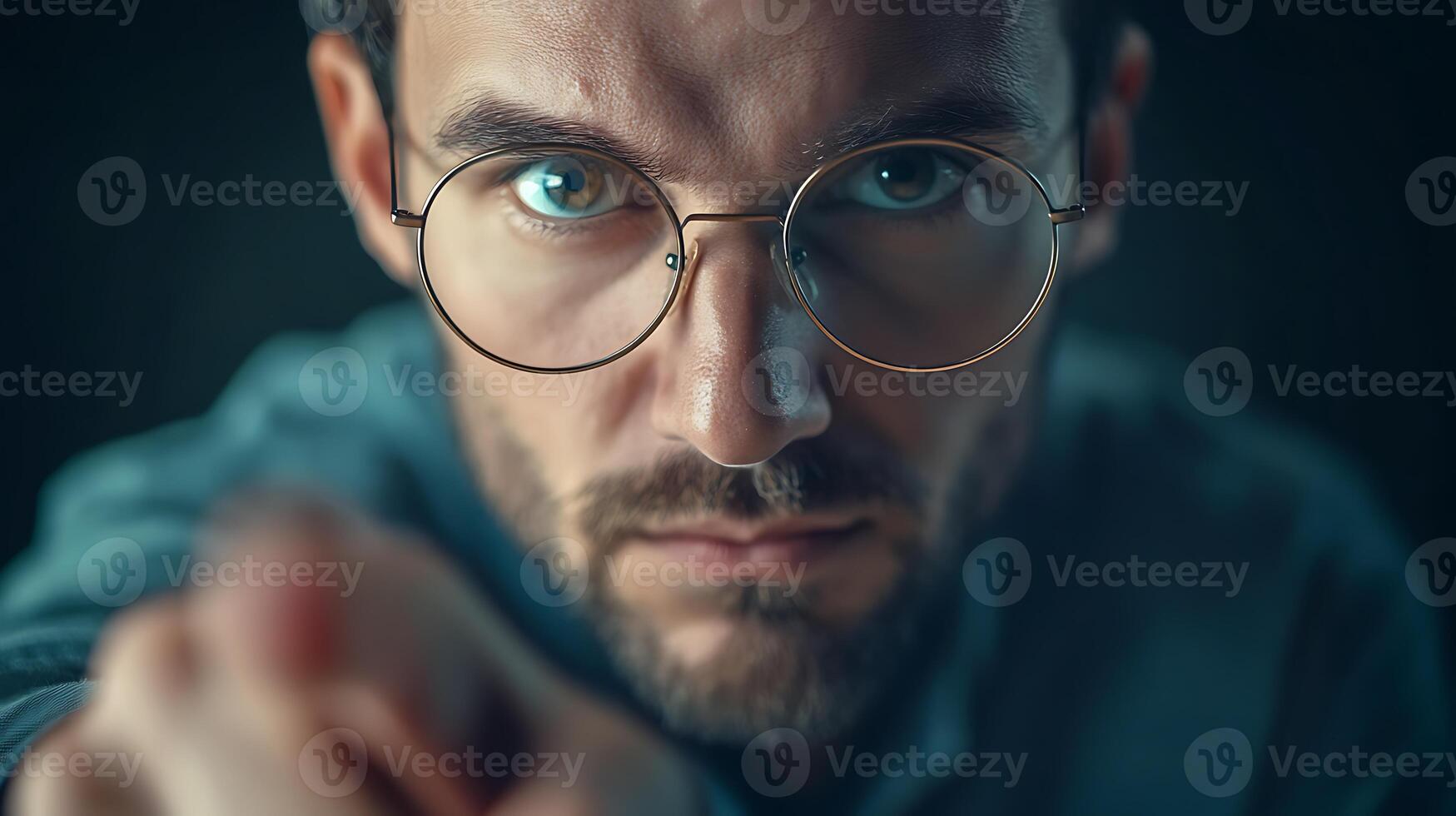 Man with glasses pointing directly at the viewer with a serious expression on his face close up shot photo