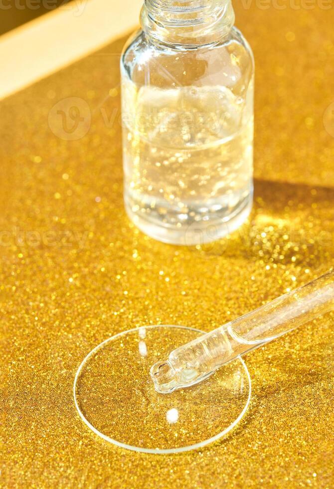 Clear serum dropper with golden background for skincare and beauty treatments. photo
