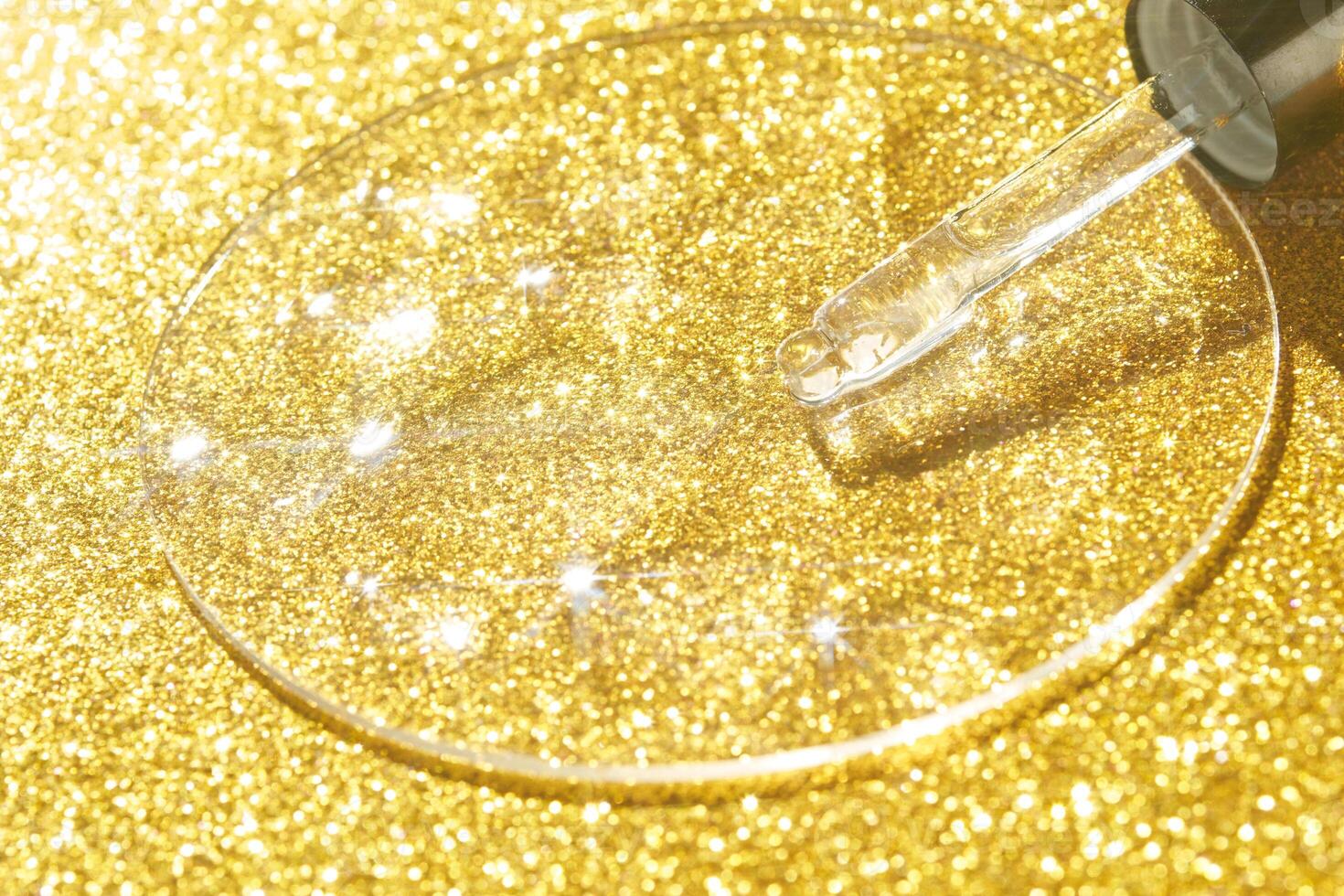 Skincare serum dropper with golden background and sparkling glitter highlights. photo