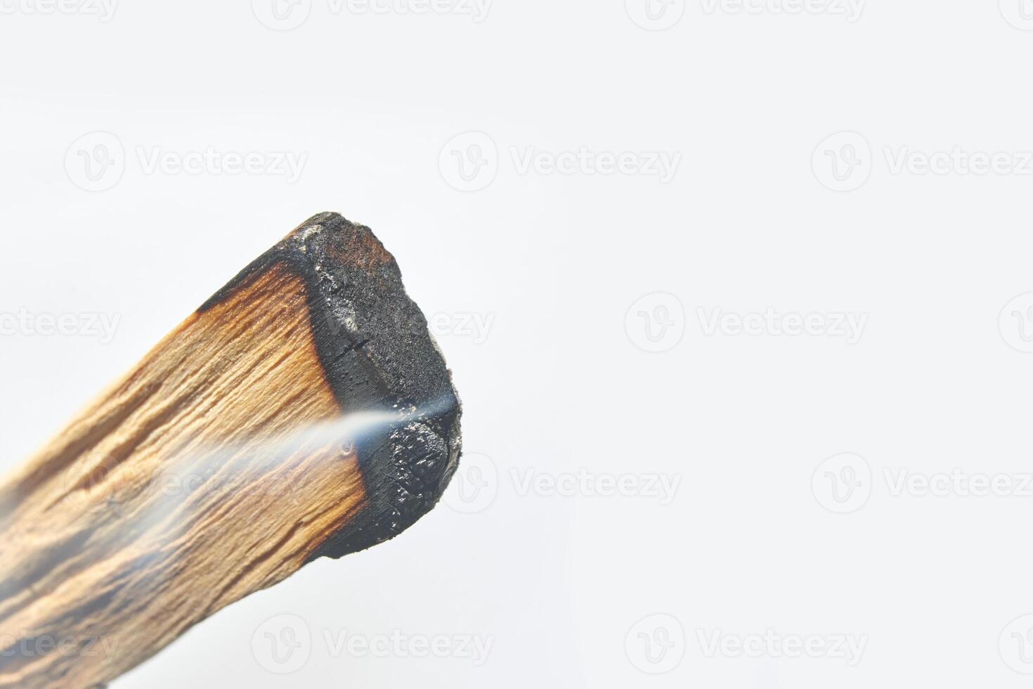 Close up of smoldering palo santo stick with thin smoke on white background. photo