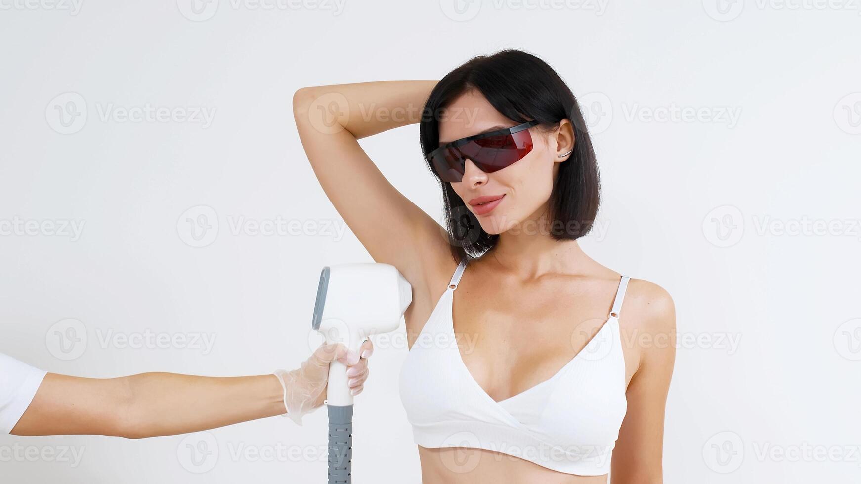 Laser epilation, hair removal procedure, young beautiful caucasian smiling brunette woman against white background, armpits epilation, spa and cosmetology concept photo