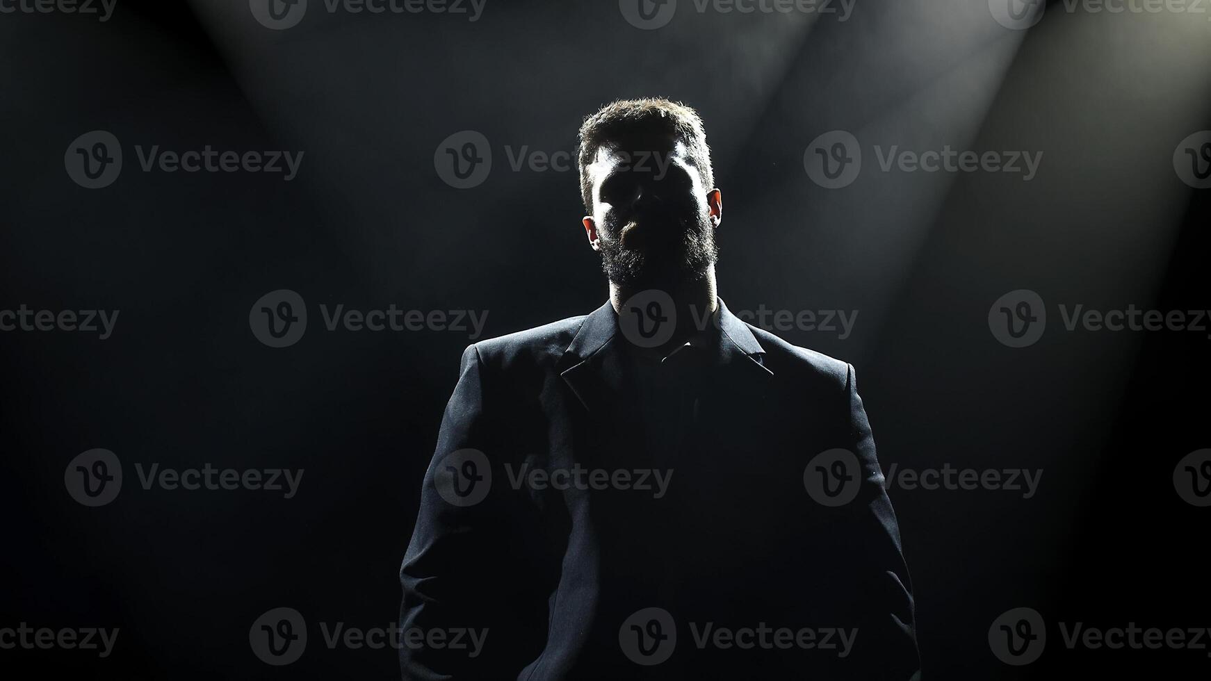 Dark silhouette of bearded man in backlight against black background. Handsome, stylish male posing in a business suit. Copy space for text, banner, ads photo
