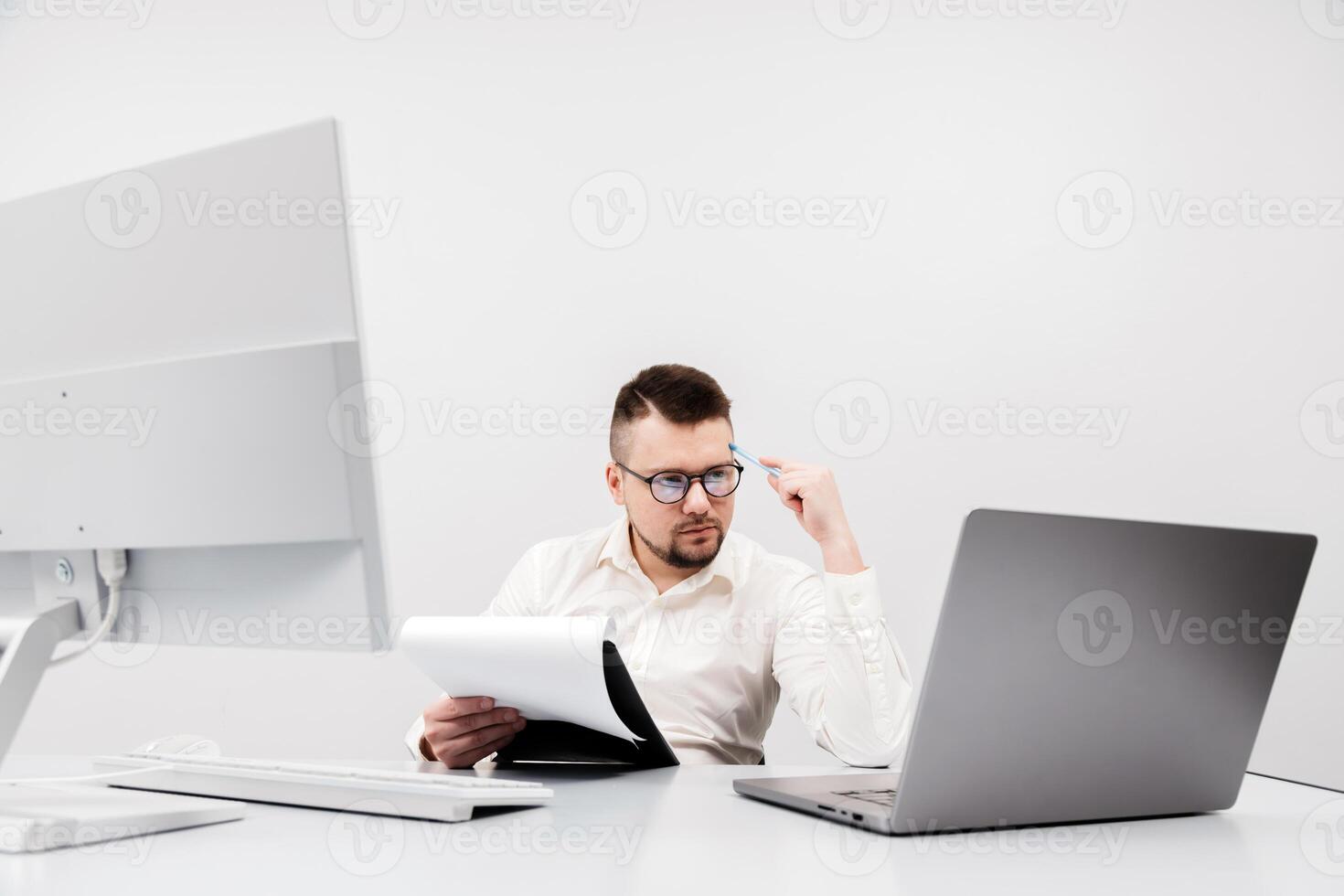 A businessman, financial manager or recruiter, works at a computer in a modern office. The concept is to show the focus and productivity photo