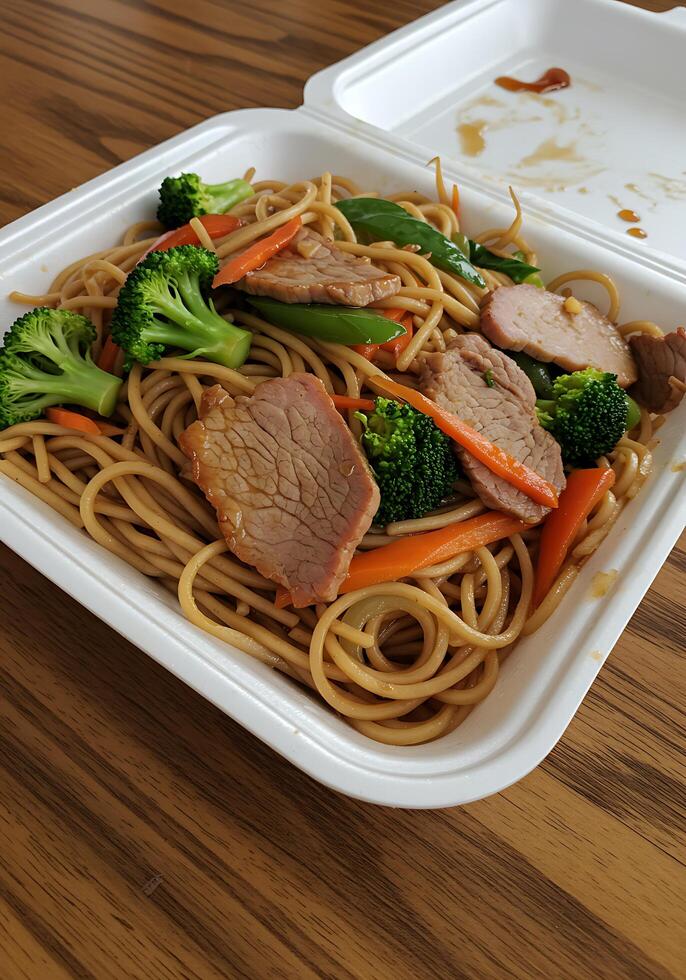 A white container with meat and vegetables photo
