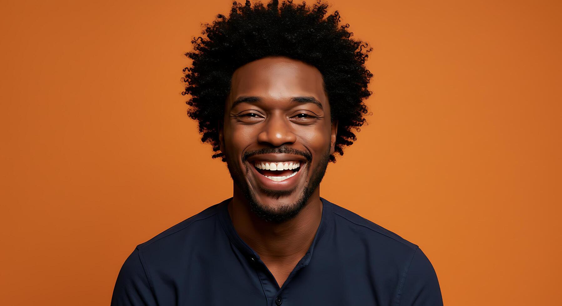 A smiling man with an afro on an orange background photo