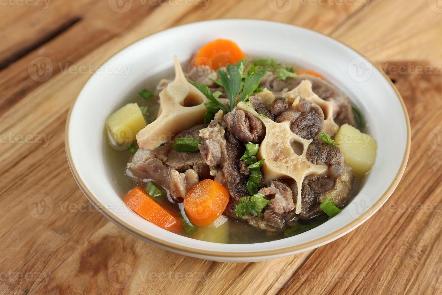 Indonesian Oxtail Soup or Sop Buntut on White Bowl photo