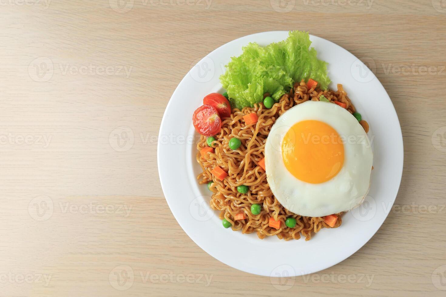 Fried Noodle Indomie Goreng with Sunny Side Egg Top View photo