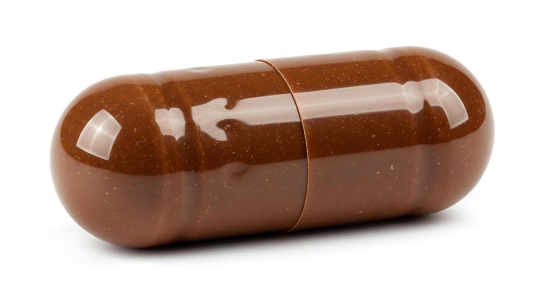 A brown pill on a white surface photo
