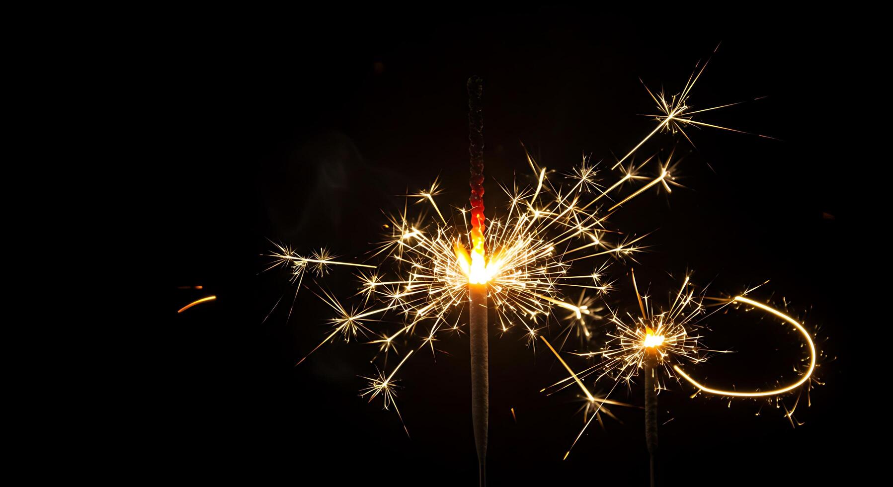 A sparkler is lit up in the dark photo