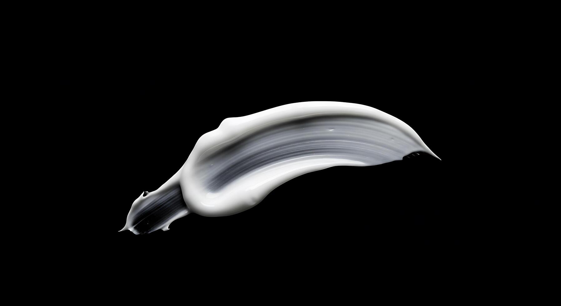 A white liquid is flowing over a black surface photo