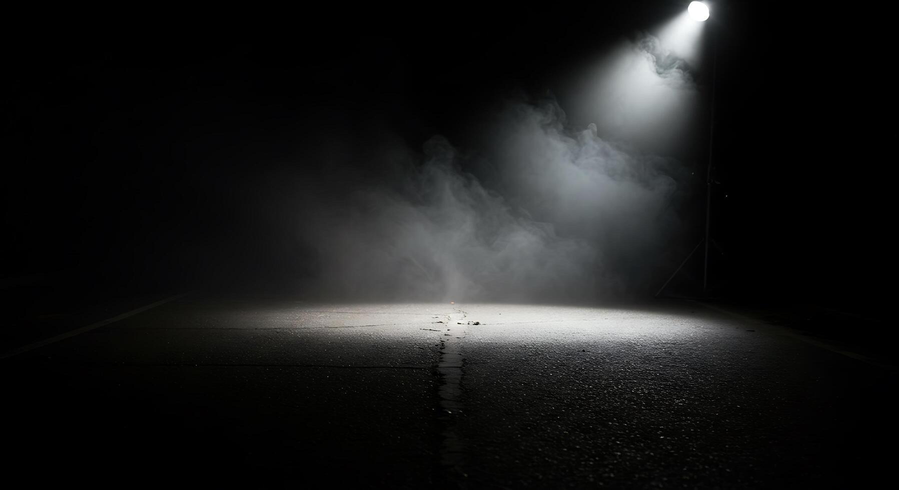 A dark road with a light shining on it photo