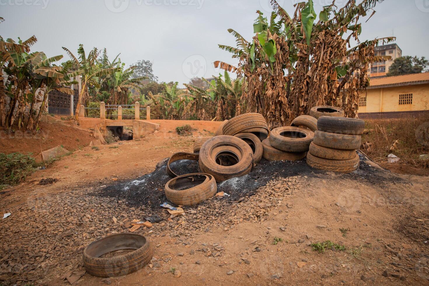 Used tires left in an illegal open landfill, they will be burned and pollute the environment, near houses in Africa, concept of pollution in Africa photo