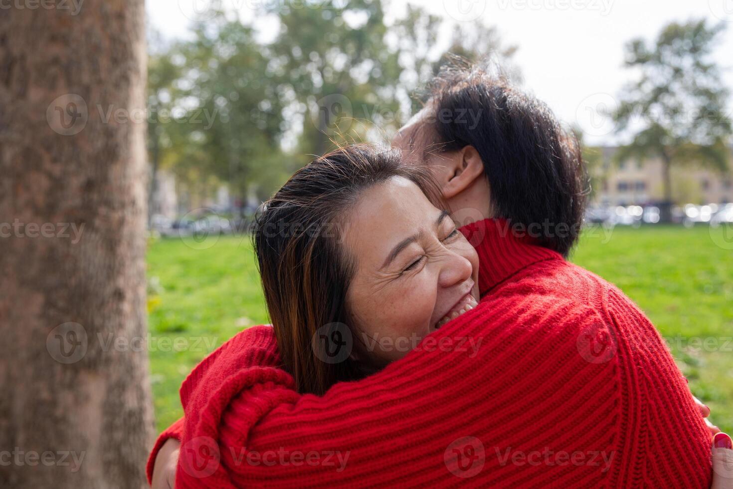 Two female friends hugging and having fun at the park. Friendship concept photo