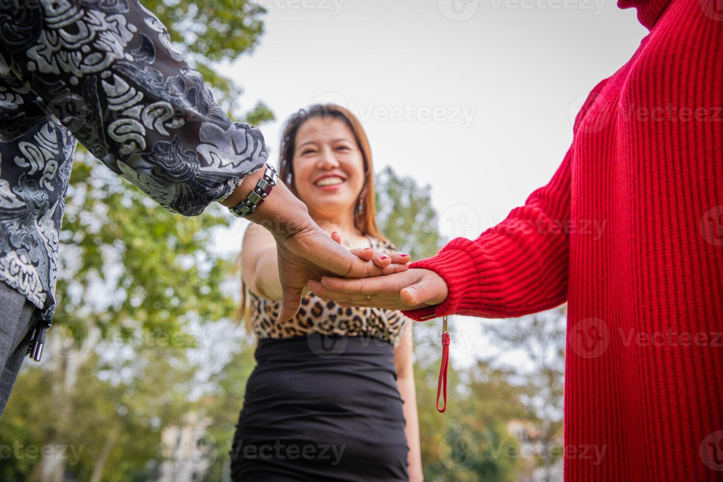 Three women of different ethnicities join hands as a sign of unity and strength. photo