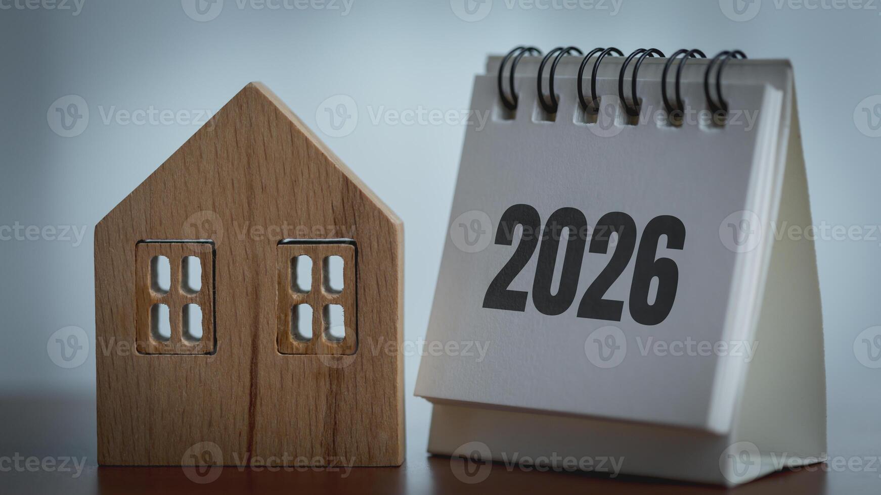 Wooden house model and a calendar with the date of the new year 2026. photo