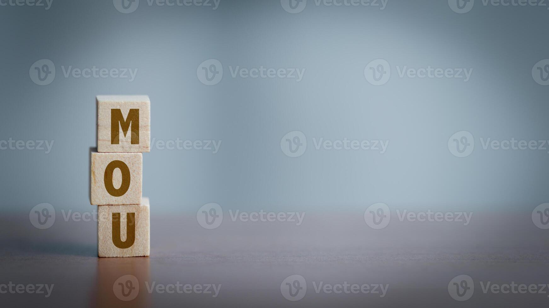 Wooden cubes with the word MOU on wooden table. photo